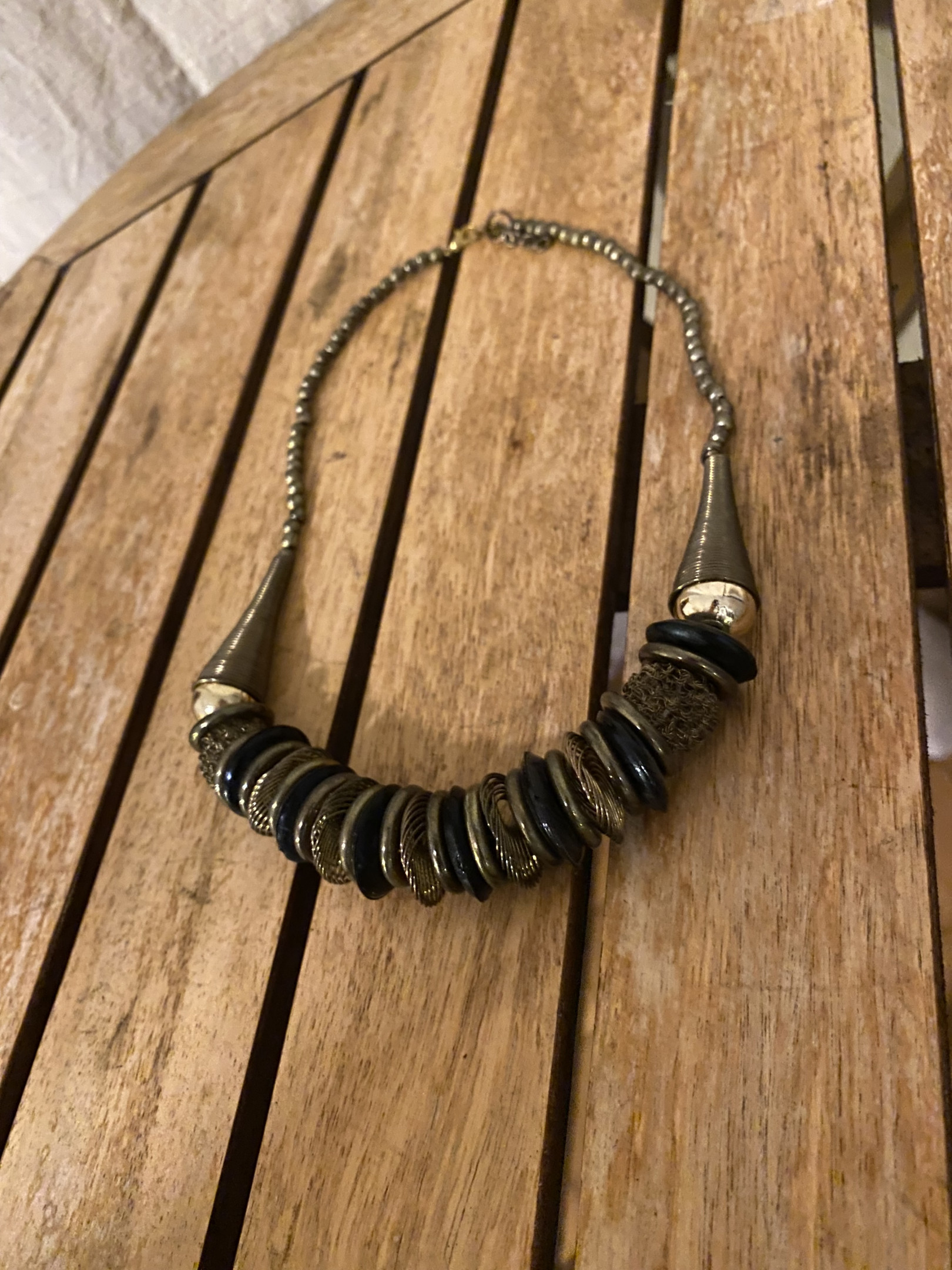 Halskette mit schwarzen und goldenen Details.