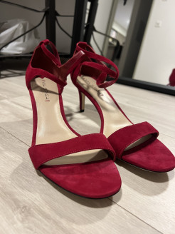 Chaussures à talon en daim rouge avec bride de cheville croisée.