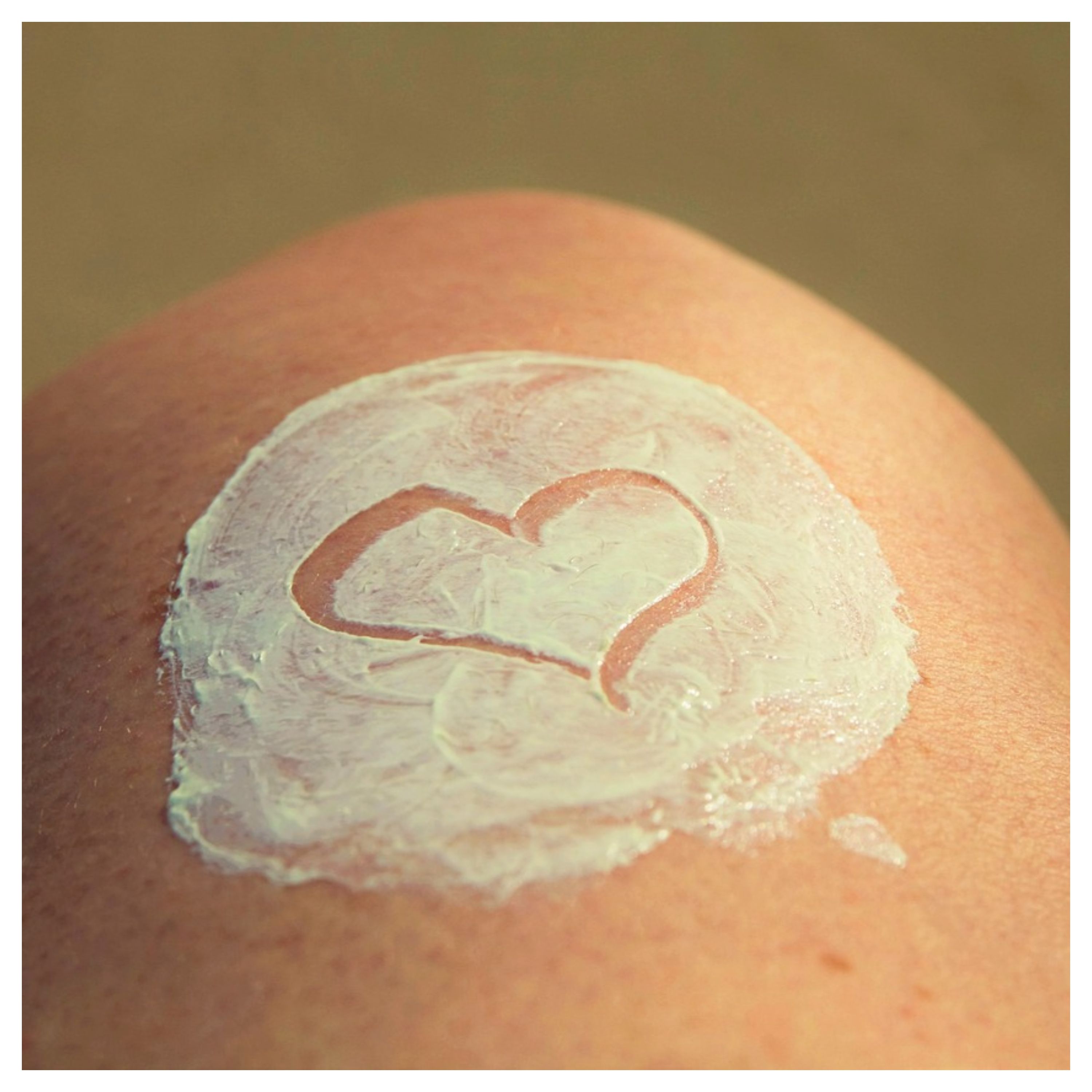 Crème solaire avec un symbole coeur sur une peau