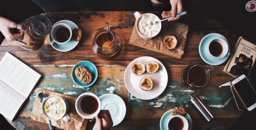 Vue de haut d'une table avec plusieurs tasses de café et des bols de petit déjeuner