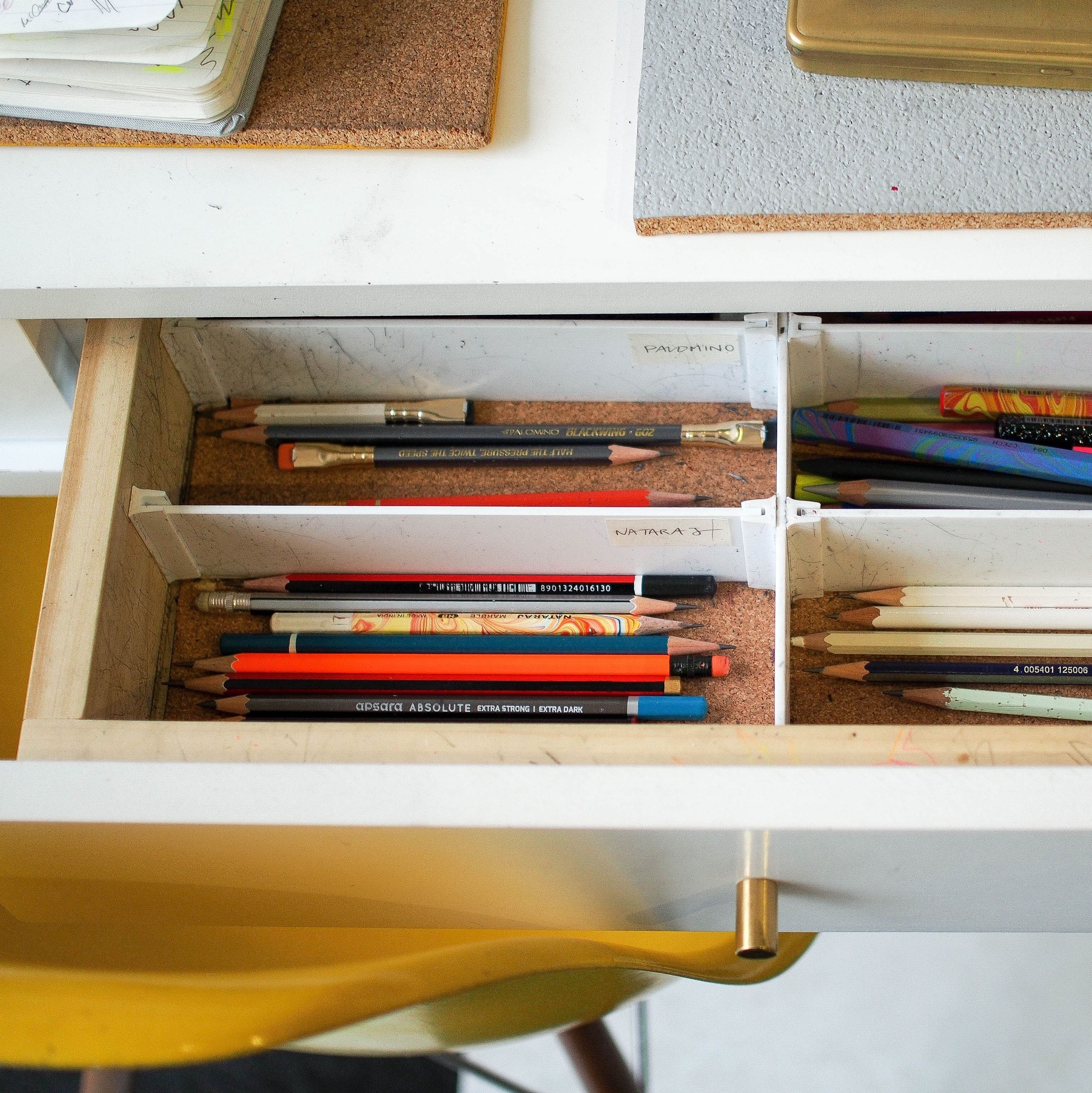 une étagère avec des livres et des crayons