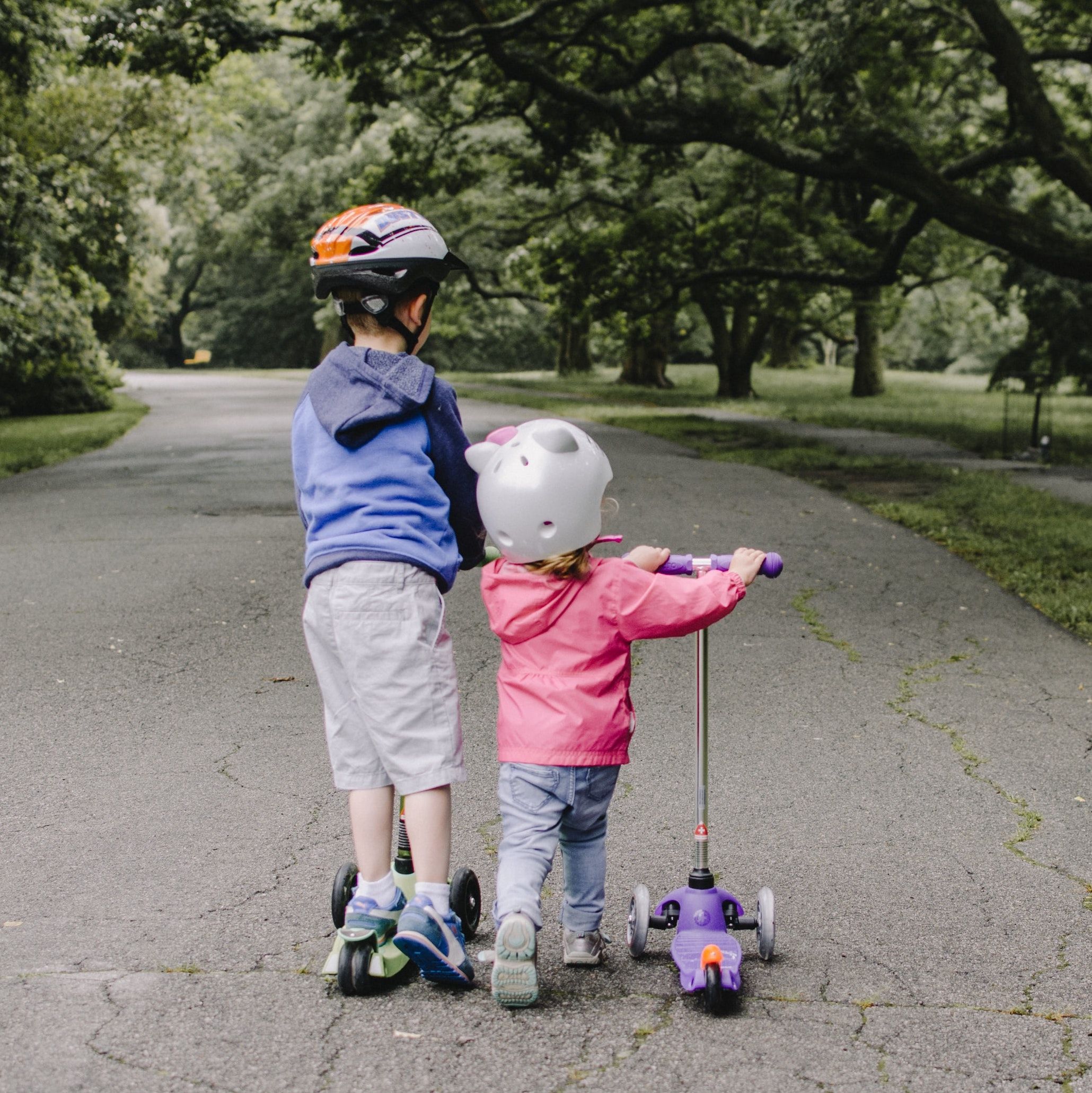 un couple d’enfants sur un scooter avec des casques et des scooters