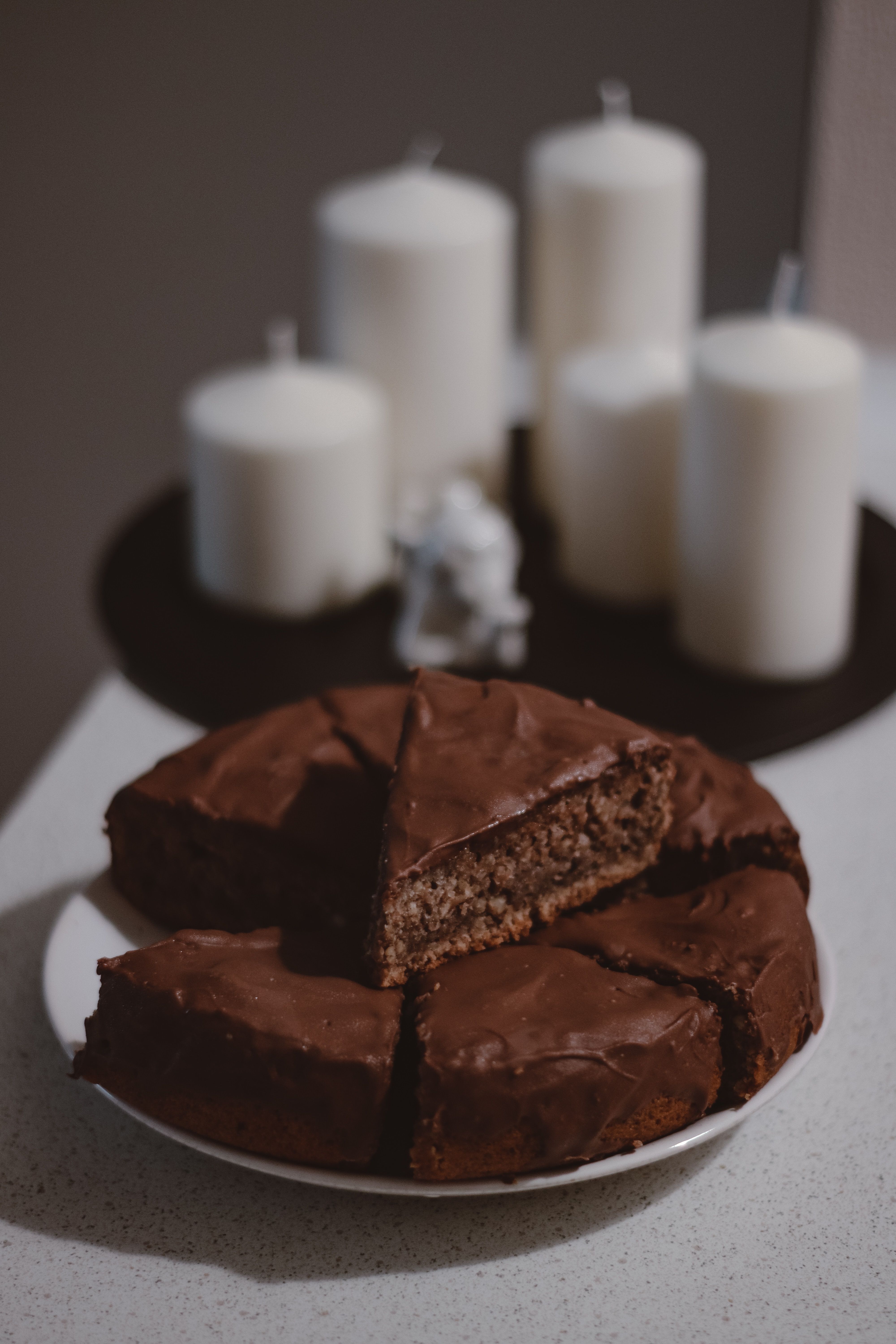 Parts de gâteaux au chocolat avec des bougies blanches en fond