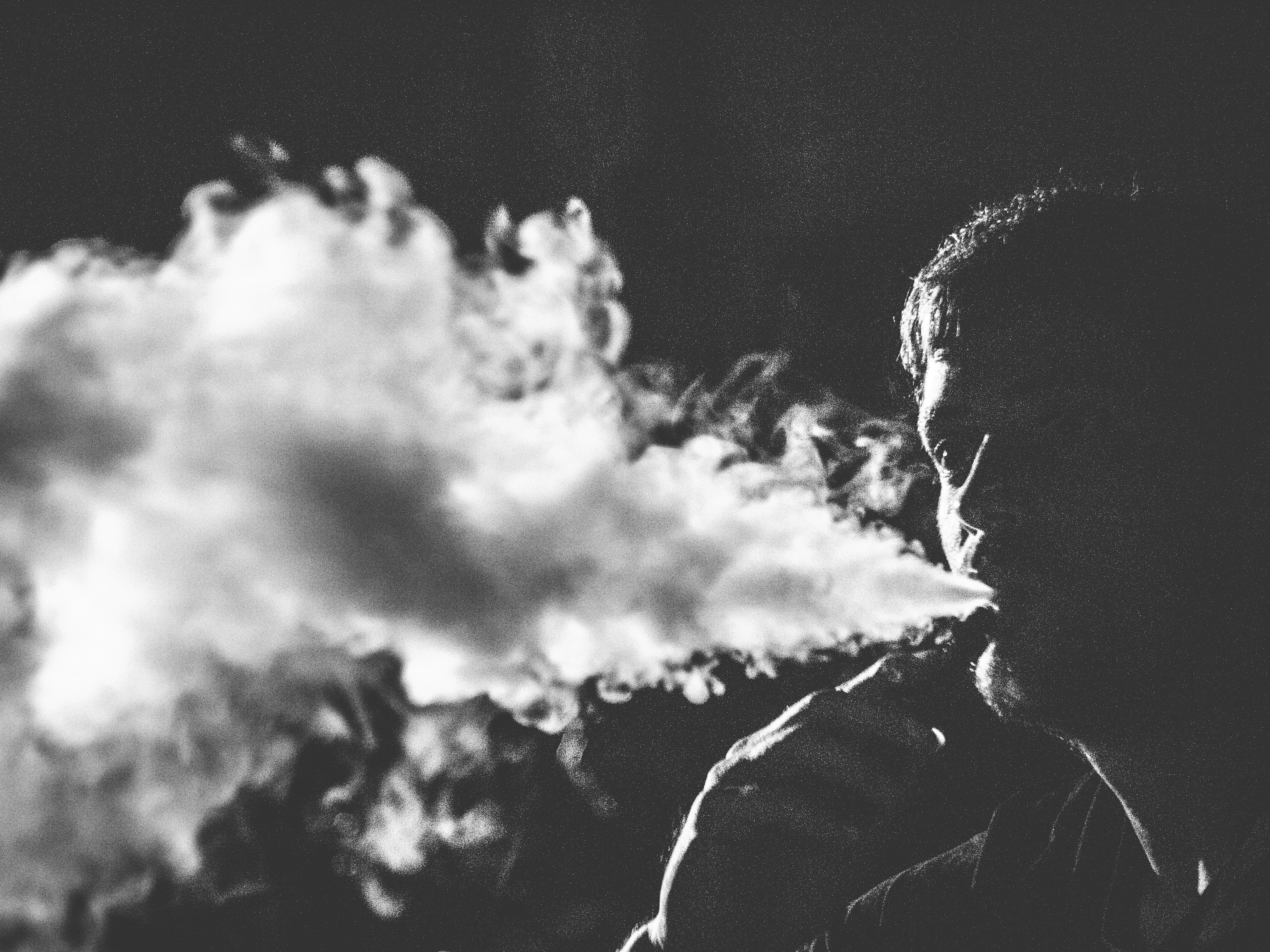 Un homme envoie de la fumée vapeur depuis sa cigarette électronique
